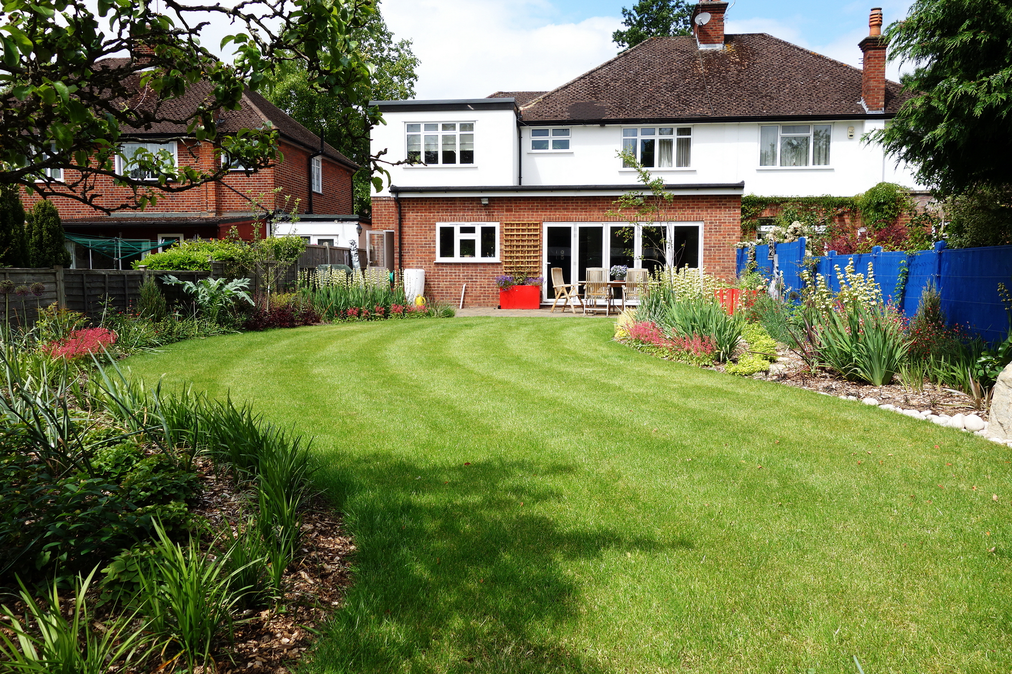 Garden planting design for Ickenham: Sweeping lawn and lots of colour is now in the garden