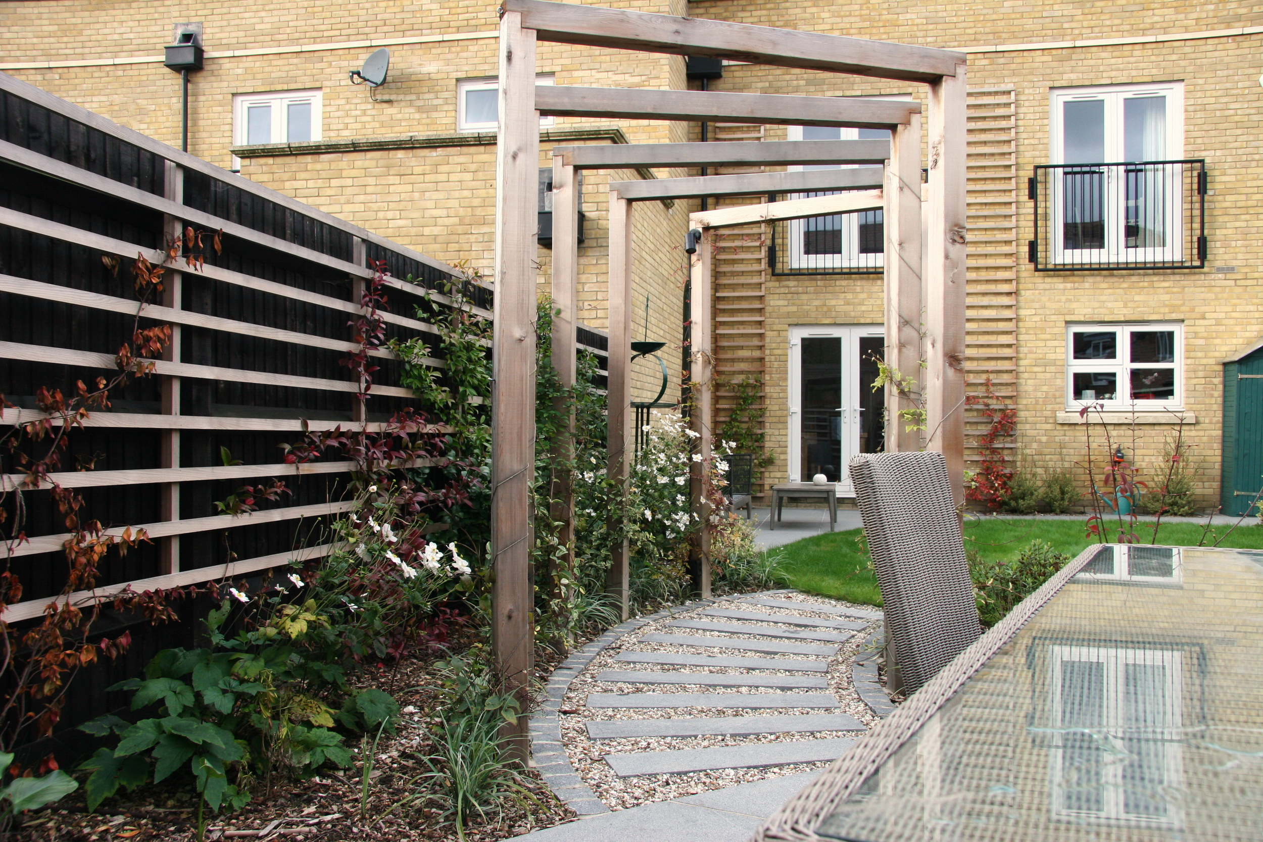 Garden ideas with Pergola over path leading from house to patio